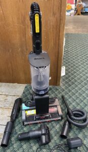 Close-up of a hand removing the detachable lithium-ion battery from the Shark Stratos Cordless IZ862H vacuum body.