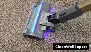 Close-up view of the Shark PowerDetect floor nozzle testing debris pickup with its active dirt detection lights illuminated