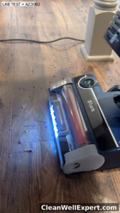 Shark Stratos Upright AZ3002 floorhead LED lights illuminating pet hair test on hardwood floor