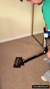 A person using the flexible Shark Stratos MultiFLEX wand to easily vacuum underneath furniture without bending down