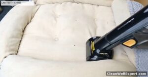 Shark UltraCyclone CH951 handheld vacuum with motorized Pet Power Brush cleaning loose fur on a cream pet bed